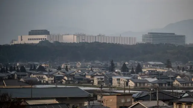 A general view of the Japan Advanced Semiconductor Manufacturing Company, pictured in the background behind a Japanese town