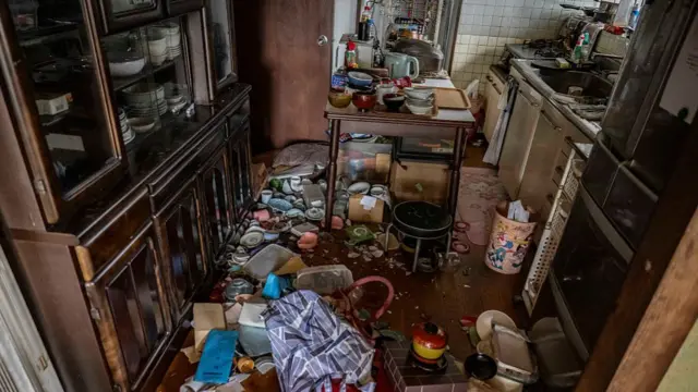 Dishes and other kitchen items are scattered on the ground