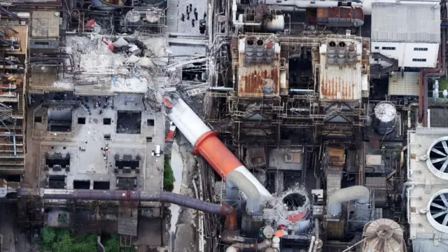 An aerial view shows a collapsed chimney at Nippon Paper Industries factory