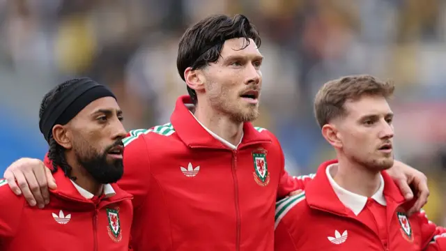 orba Thomas (l) Kieffer Moore (c) and David Brooks of Wales look on during the national anthem during the international friendly match between Wales and Ghana at Cardiff City Stadium on June 02, 2026 in Cardiff, Wales