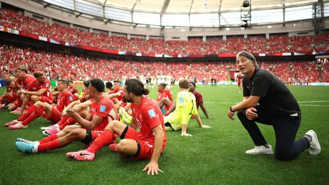 Murat Yakin and Switzerland players sit on the pitch
