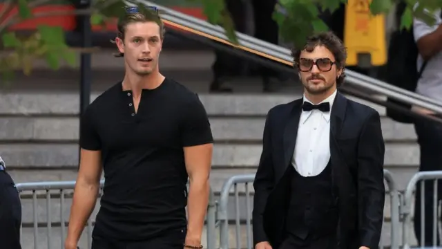 Benson Boone arrives at Madison Square Garden wearing a tux and orange tinted sunglasses
