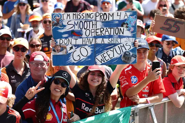 Fans hold up signs for Carlos Sainz