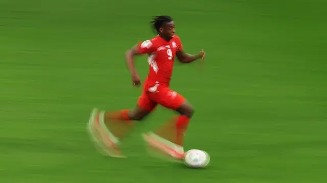 Johan Manzabi running with the ball with blurred geet