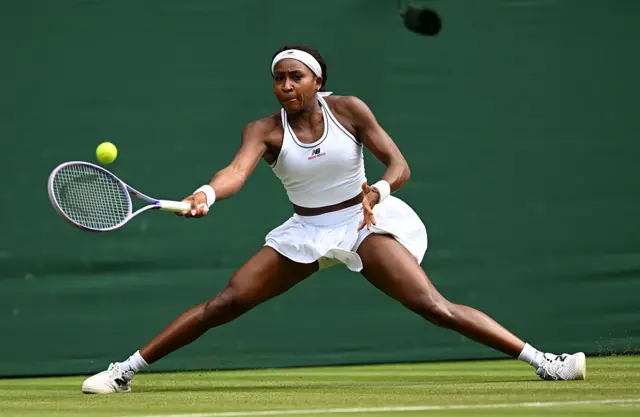 Coco Gauff hits a tennis ball with a racquet