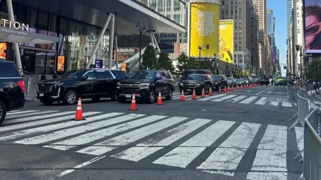 Black cars line up outside Madison Square Garden next to traffic cones and metal barriers
