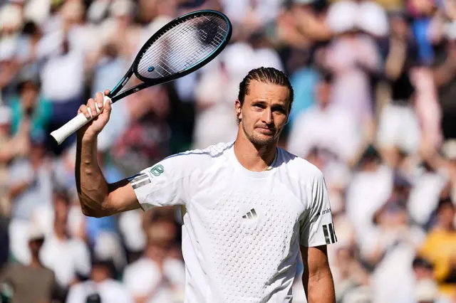 Alexander Zverev holds up a racquet