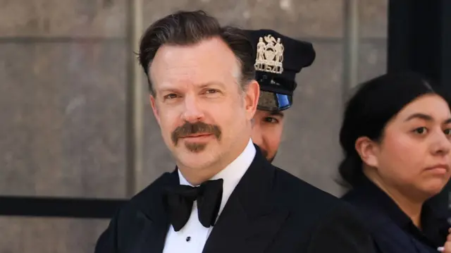 US actor Jason Sudeikis motions from his black SUV as he arrives at Madison Square Garden