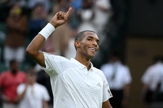 Felix Auger-Aliassime holds up his arm