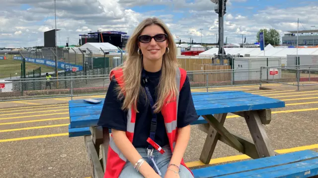 Silverstone entertainment co-ordinator Florence Sheppard sat on a bench at the circuit