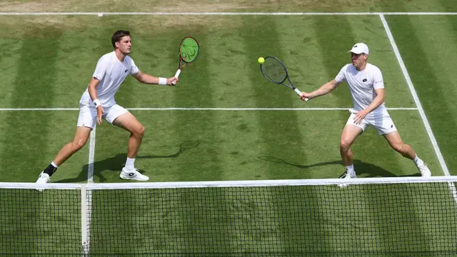 Harri Heliovaara of Finland plays a forehand with partner Henry Patten of Great Britain