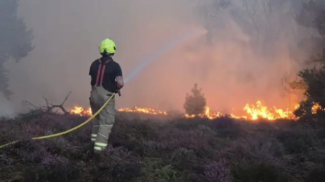 A firefighter douses flames