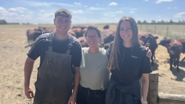 Nicola Goodings stands with her two children, Will and Louise at Green Farm in Wicklewood, with Red Poll cattle in the background