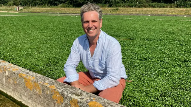 Tom Amery sits in the watercress beds at Drayton Farm in Alresford
