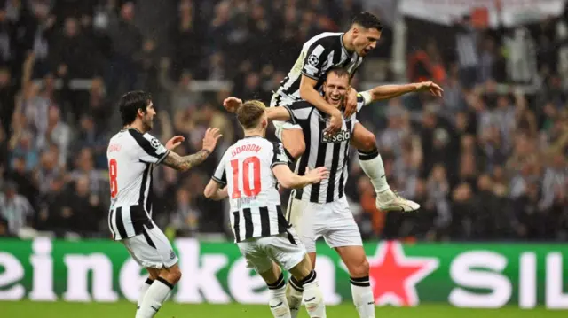 Dan Burn of Newcastle United celebrates with Sandro Tonali, Anthony Gordon and Fabian Schaer of Newcastle United after scoring the team's second goal during the UEFA Champions League match between Newcastle United FC and Paris Saint-Germain at St. James Park on October 04, 2023 in Newcastle upon Tyne, England