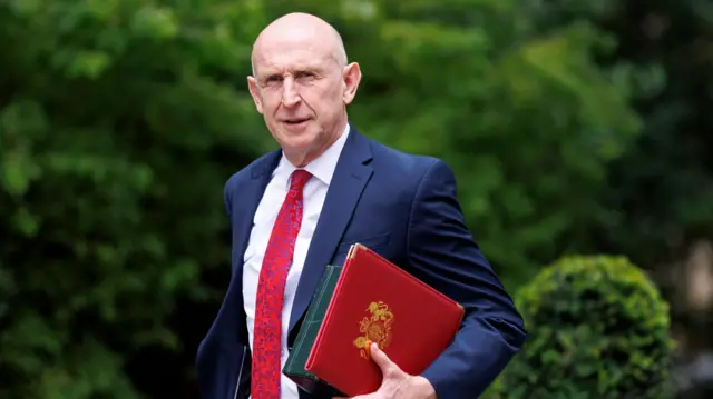 John Healey, wearing a suit.
