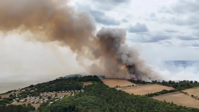 Smoke rises from a wildfire at Dunwich Heath