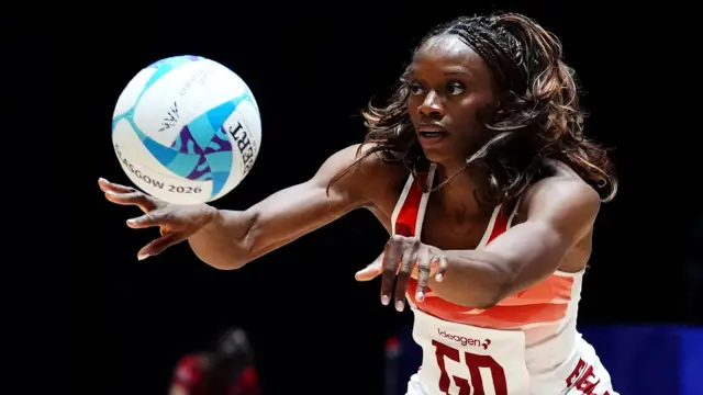 Funmi Fadoju, wearing England's white and red netball vest top, passes the ball during the win over Tonga at the Commonwealth Games