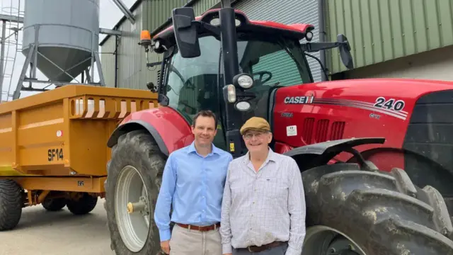 Father and son duo James and Simon Marriage stand next to a red tractor