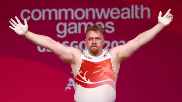 England's Andrew Griffiths raises his arms to celebrate his medal
