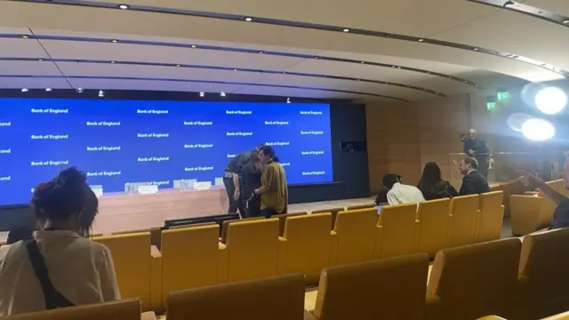 Bloomberg room with seats, screen and a spotlight.