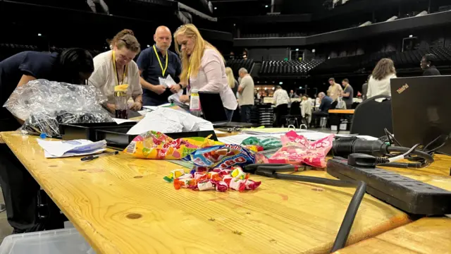Packets of sweets open on a table with counters in the background.
