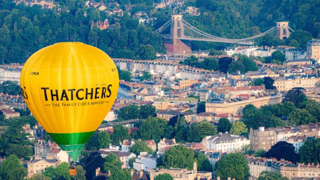 A Thatchers balloon flying in front of the Clifton Suspension Bridge