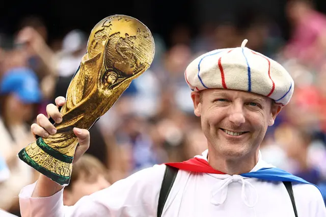 France fan holding a replica World Cup trophy