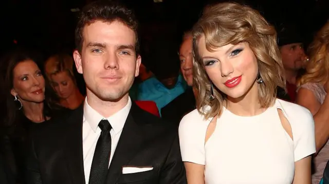 Austin Swift and Taylor Swift seated together in the audience of an awards show