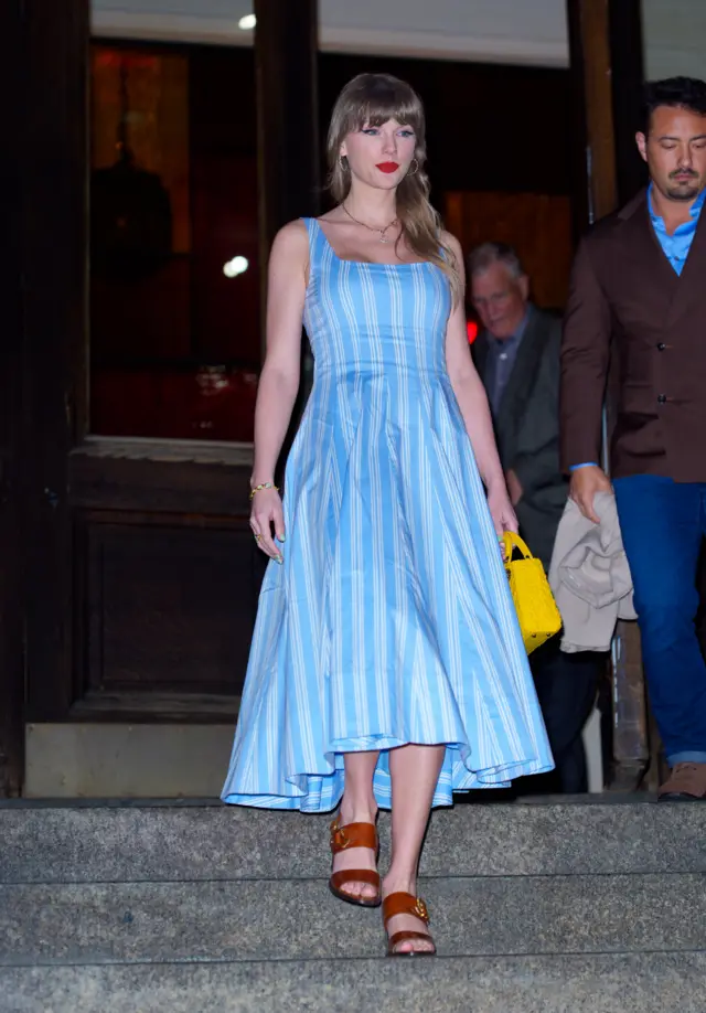 Taylor Swift holds a yellow Dior purse
