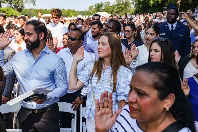New US citizens raise their right hands to take the Naturalization Oath of Allegiance during a naturalization ceremony at George Washington's Mount Vernon in Mount Vernon, Virginia