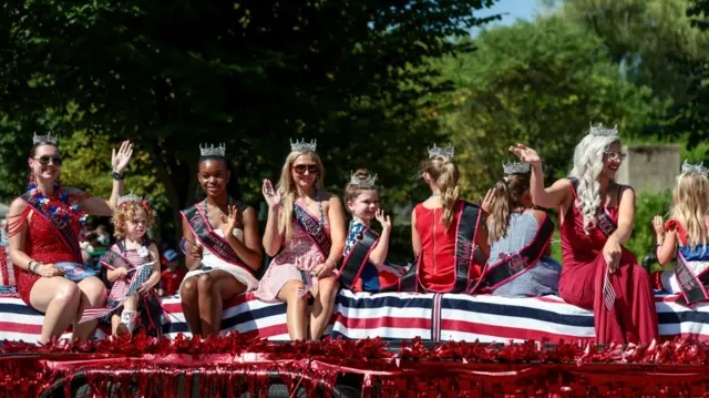Parade participants wave to the crowd during an Independence Day parade as the United States celebrates its 250th anniversary in Staunton, Virginia
