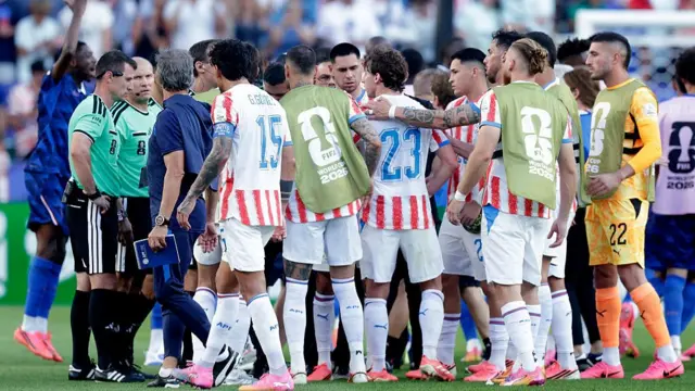 Players of Paraguay argues with Referee Ilgiz Tantashev