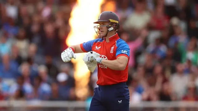 Jacob Bethell taps his bat in celebration