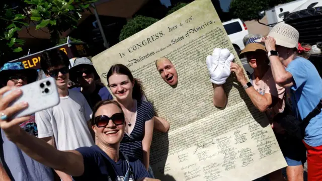 Members of the public take photographs of a man dressed as the Declaration of Independence in Philadelphia