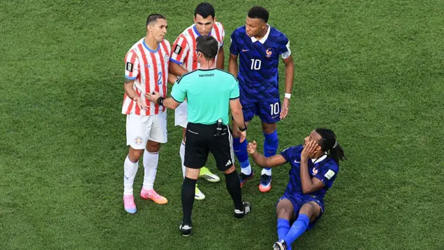 Gustavo Velazquez of Paraguay, Junior Alonso of Paraguay and Kylian Mbappe of France argue with referee Ilgiz Tantashev