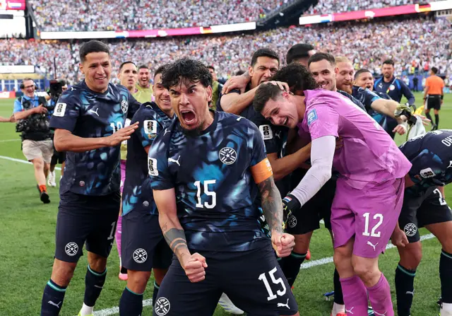 Paraguay players celebrate beating Germany