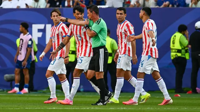 Paraguay players and the referee