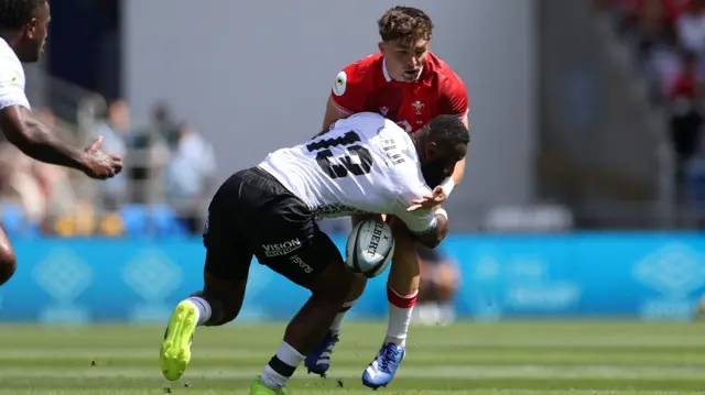 Dan Edwards of Wales is tackled by Semi Radradra of Fiji