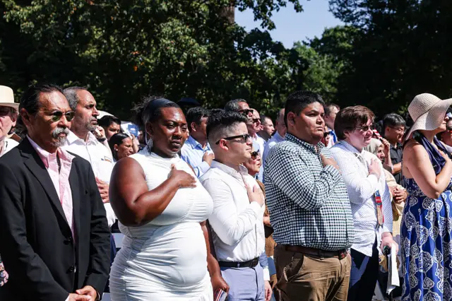 New US citizens listen to the Star-Spangled Banner during a naturalization ceremony at George Washington's Mount Vernon in Mount Vernon.