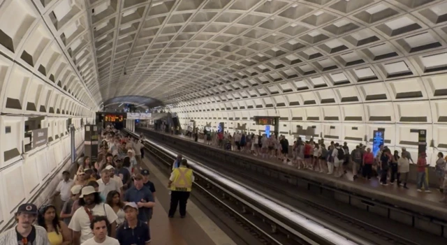 Dozen people line the platforms of a metro station
