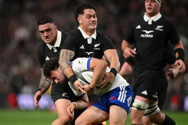 Antoine Hastoy of France is tackled by Quinn Tupaea of New Zealand