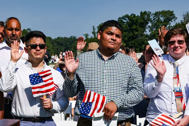 New US citizens raise their right hands to take the Naturalization Oath of Allegiance during a naturalization ceremony at George Washington's Mount Vernon in Mount Vernon