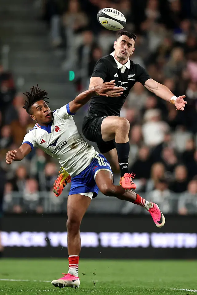 Will Jordan of the New Zealand All Blacks and Theo Attissogbe of France contest the high ball