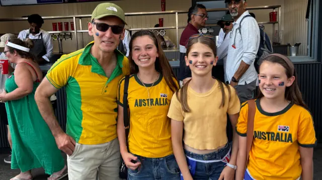 Man and three daughters (left to right) wearing yellow to support Australia