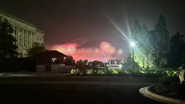 Red and yellow fireworks light up the night sky over the US Library of Congress.
