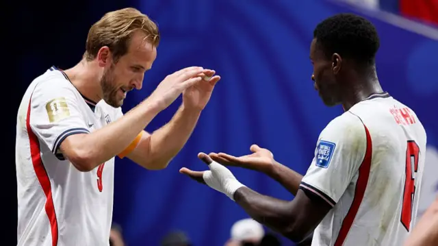Harry Kane and Marc Guehi do high fives