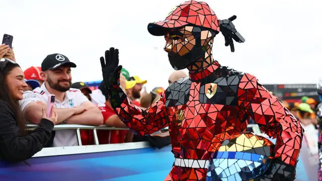 An entertainer dressed as Lewis Hamilton