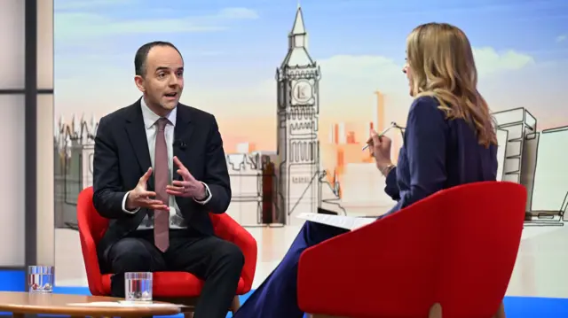 James Murray being interviewed by Kunessberg, both sat on red chairs.