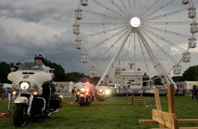 Police ride motorcycles, while people seek shelter during the Great American State Fair on the National Mall, marking the 250th anniversary of U.S. Independence, as inclement weather moves across the area, in Washington,
